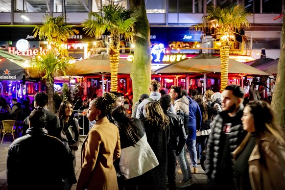 epa09748008 Nightlife crowd on the town hall square in Rotterdam, The Netherlands, late 11 February 2022. The Dutch cabinet aims to have most coronavirus pandemic restrictive measures come to an end s ...