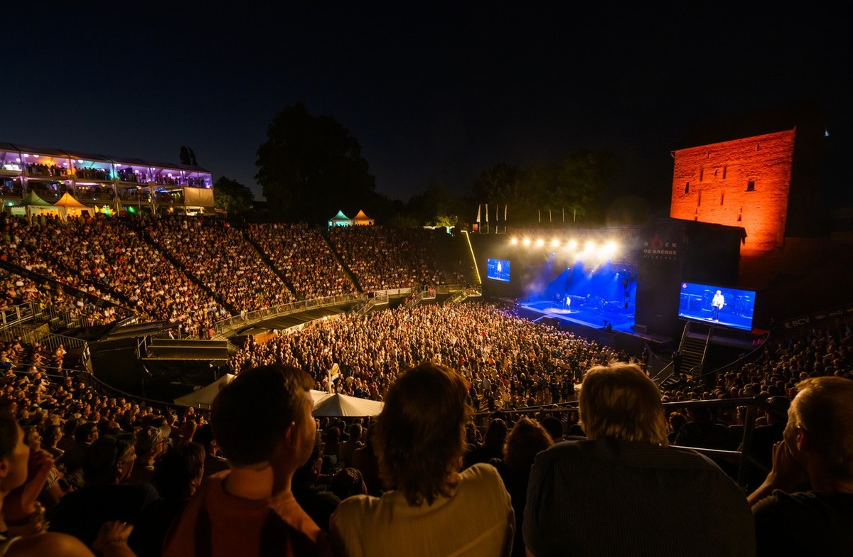 Les festivaliers ecoutent le concert du groupe britannique Status Quo sur la scene des arenes lors de la 30eme edition du Festival Rock Oz'Arenes le mercredi 10 aout 2022 dans l'amphitheatre ...