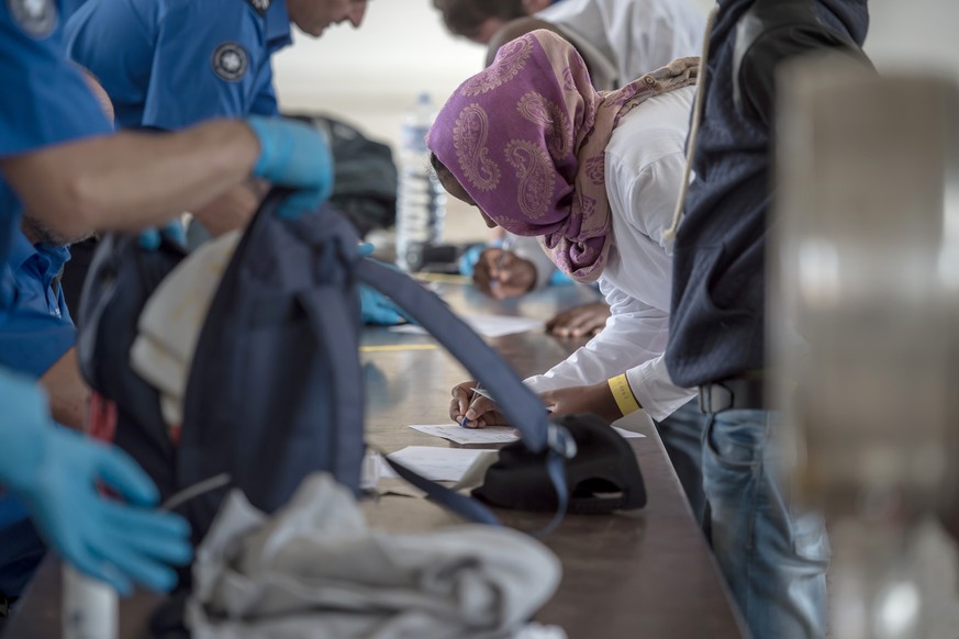 Migranten am Bahnhof Chiasso werden von der Grenzwache in Empfang genommen.