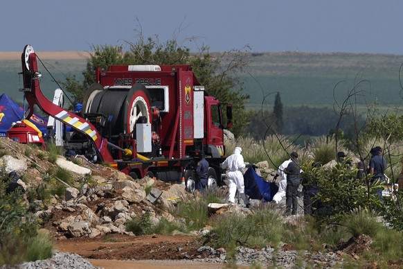 Forensic service workers carry remains in blue body bags during a rescue operation to rescue miners from below ground in an abandoned gold mine in Stilfontein, South Africa, Tuesday, Jan. 14, 2025. (A ...