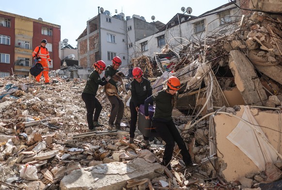 epa10479891 US members of Humane Society International rescue a dog with five puppies from the rubble after powerful earthquake in Hatay, Turkey, 20 February 2023. More than 45,000 people have died an ...