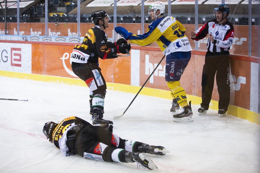 Berns Eric Blum liegt nach einem Check von Davos' Fabrice Herzog, rechts, auf dem Eis, im Eishockey Meisterschaftsspiel der National League zwischen dem SC Bern und HC Davos, am Sonntag, 14. Febr ...