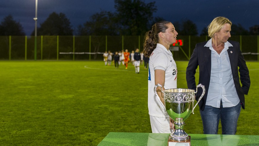 Die Zuercherin Fabienne Humm, rechts, wartet gemeinsam mit der Trainerin der Schweizer Frauen Fussballnationalmannschaft, Martina Voss-Tecklenburg, links, auf die Pokaluebergabe nach dem Gewinn der Sc ...