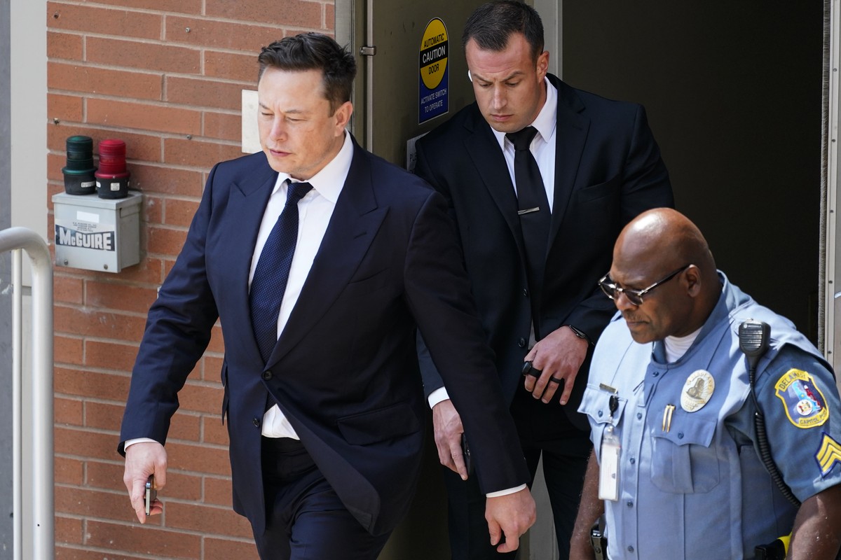 CEO Elon Musk, left, departs from the justice center in Wilmington, Del., Tuesday, July 13, 2021. Testifying for a second day, Musk pushed back again Tuesday against a lawsuit that blames him for engi ...