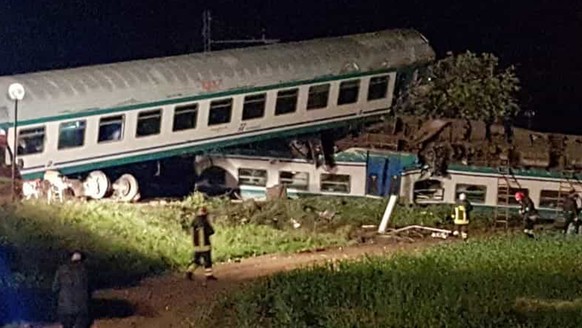 Firemen and rescue personnel work next to a train that plowed into a big-rig truck that was on the tracks, killing the train&#039;s engineer and injuring 16 passengers near Turin, northern Italy, earl ...