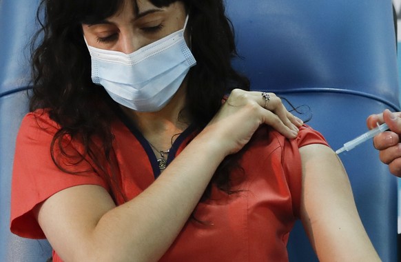 Dr. Estefania Zevrnja gets a shot of Russia&#039;s Sputnik V vaccine for COVID-19 at Dr. Pedro Fiorito Hospital in Avellaneda, Argentina, Tuesday, Dec. 29, 2020. (AP Photo/Natacha Pisarenko)