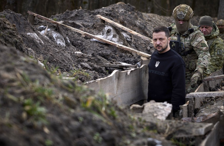 epa10547200 A handout photo made available by the Ukrainian Presidential Press Service shows Ukrainian President Volodymyr Zelensky walking through a trench at an undisclosed position of Ukrainian fro ...