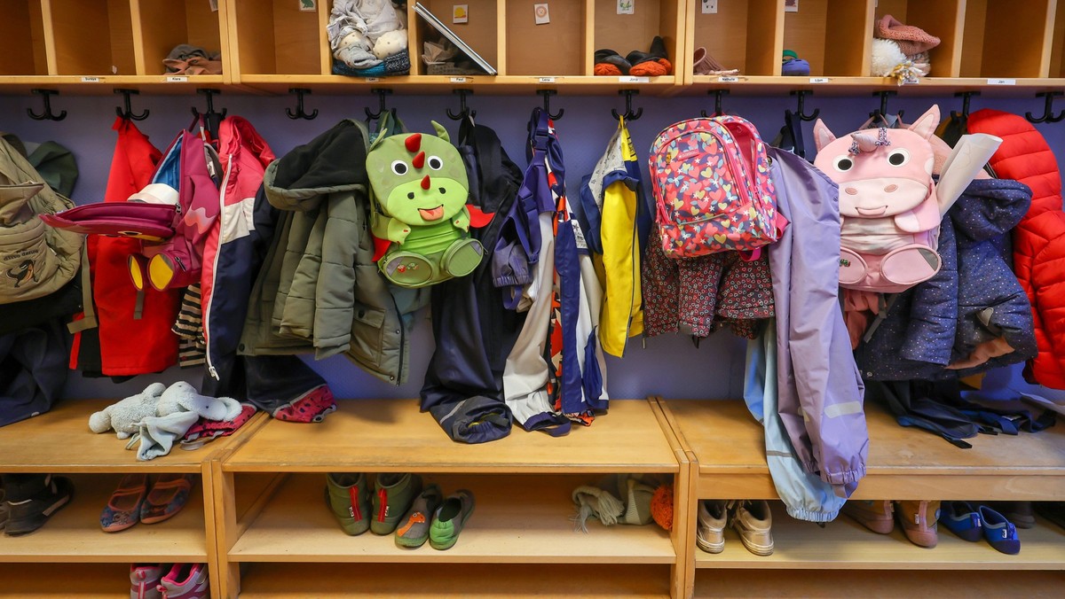 Deutschland - Symbolbild KITA. Maentel, Jacken, und Einhorn Rucksaecke von Kindern haengen an einer Garderobe in einem Kindergarten. Deutschland *** Germany symbolic image KITA coats, jackets, and uni ...