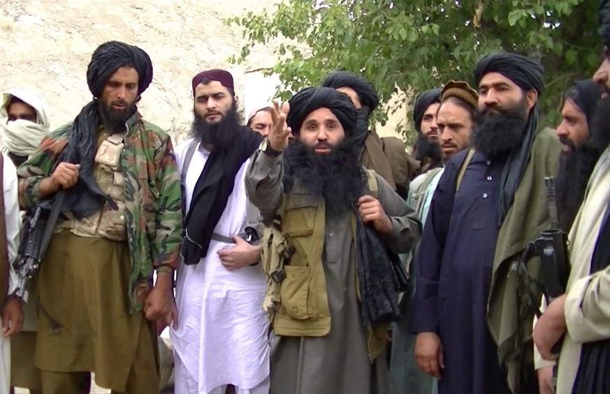 epa04533805 A video grab taken from an undated handout video released by the Tehrik-e-Taliban Pakistan (TTP) shows its head Mullah Fazlullah (C) at an undisclosed location at Pak-Afghan border. Accord ...