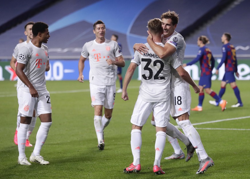 epa08604372 Joshua Kimmich (C) of Bayern Munich celebrates with teammate Leon Goretzka (R) after scoring the 5-2 lead during the UEFA Champions League quarter final match between Barcelona and Bayern  ...