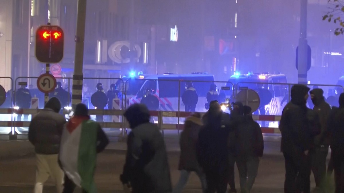 In this image taken from video, a group of pro-Palestinian protesters walk toward police line, with police vans driving in the background, near the soccer stadium in Amsterdam, Netherlands, Thursday,  ...