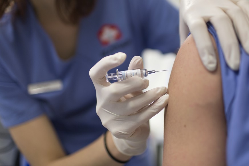 ARCHIVBILD ZUR EMPFEHLUNG DES BAG SICH GEGEN DIE GRIPPE ZU IMPFEN, AM DIENSTAG, 23. OKTOBER 2018 - A medical assistant gives a flu vaccination at the Arzthaus in Zurich, Switzerland, on January 30, 20 ...