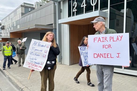 Anjuli Grantham, left, and Ben Muse protest with others outside the Alaska Division of Elections office on Friday, June 12, 2026, in Juneau, Alaska, opposing efforts to block from the ballot a U.S. Se ...