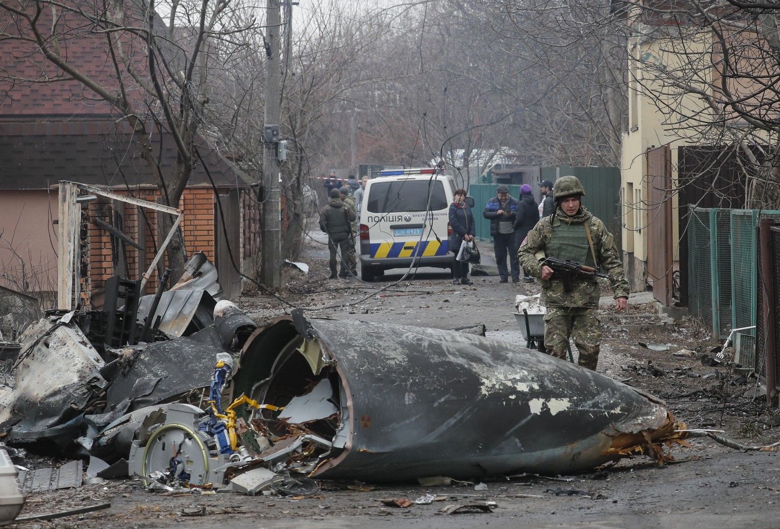 epa09783629 A soldier walks past the debris of a military plane that was shot down overnight in Kiev, Ukraine, 25 February 2022. Russian troops entered Ukraine on 24 February prompting the country&#03 ...