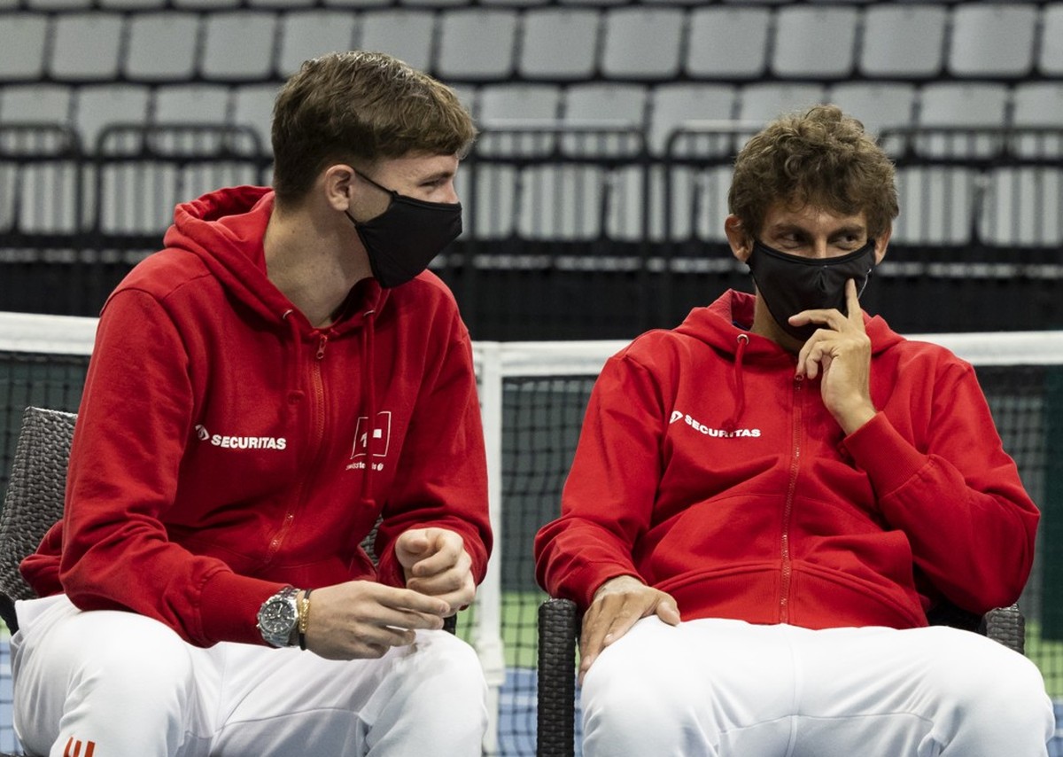 Switzerland's team captain Severin Luethi, right, talks to his players Dominic Stricker, left, and Henri Laaksonen, during the draw ceremony in the Swiss Tennis Arena in Biel, Switzerland, Thursd ...