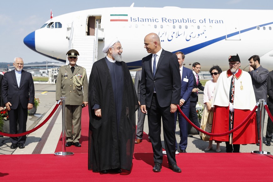 Swiss Federal President Alain Berset, right, and Iranian President Hassan Rohani, left, listen to the national anthems during Rohani&#039;s official visit to Switzerland at the Zurich airport in Klote ...