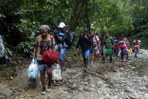epa09499997 Haitian migrants walk on their way to Panama through the Darien Gap in Acandi, Colombia, 28 September 2021 (issued 01 October 2021). In the Darien jungle, the steps and gasps of the Haitia ...