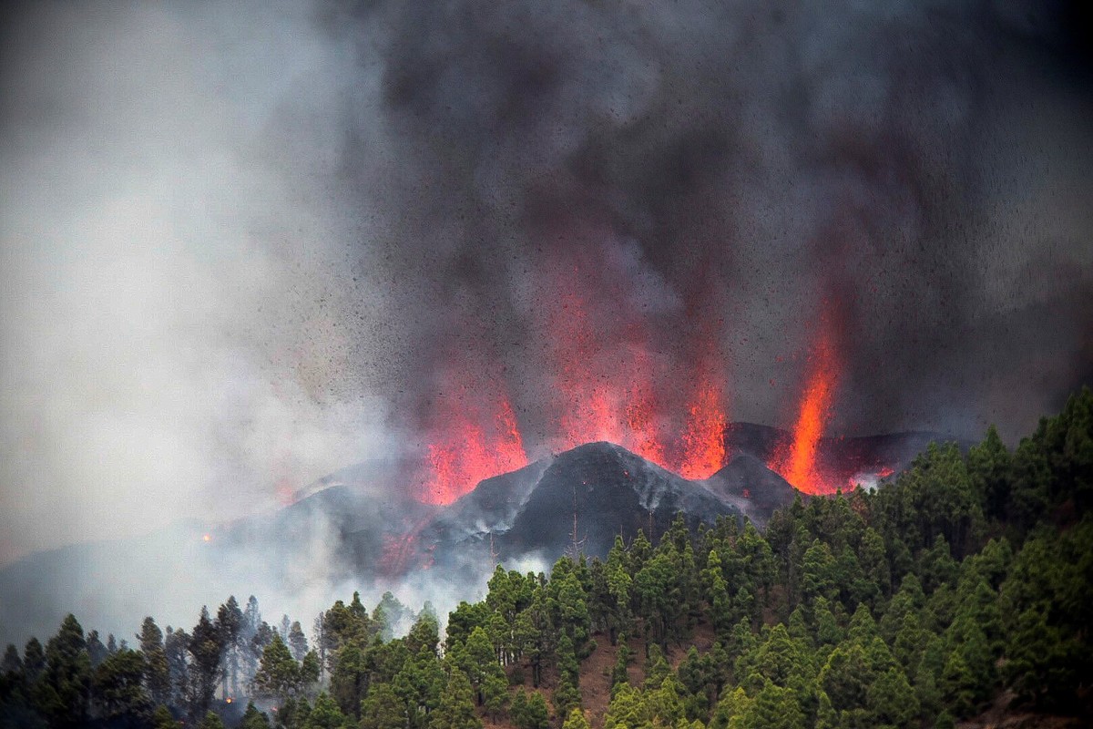 epa09476671 Smoke and magma rise to the sky from the volcanic eruption in El Paso, La Palma, Canary Islands, Spain, 19 September 2021. The area registered hundreds of small earthquakes along the week  ...