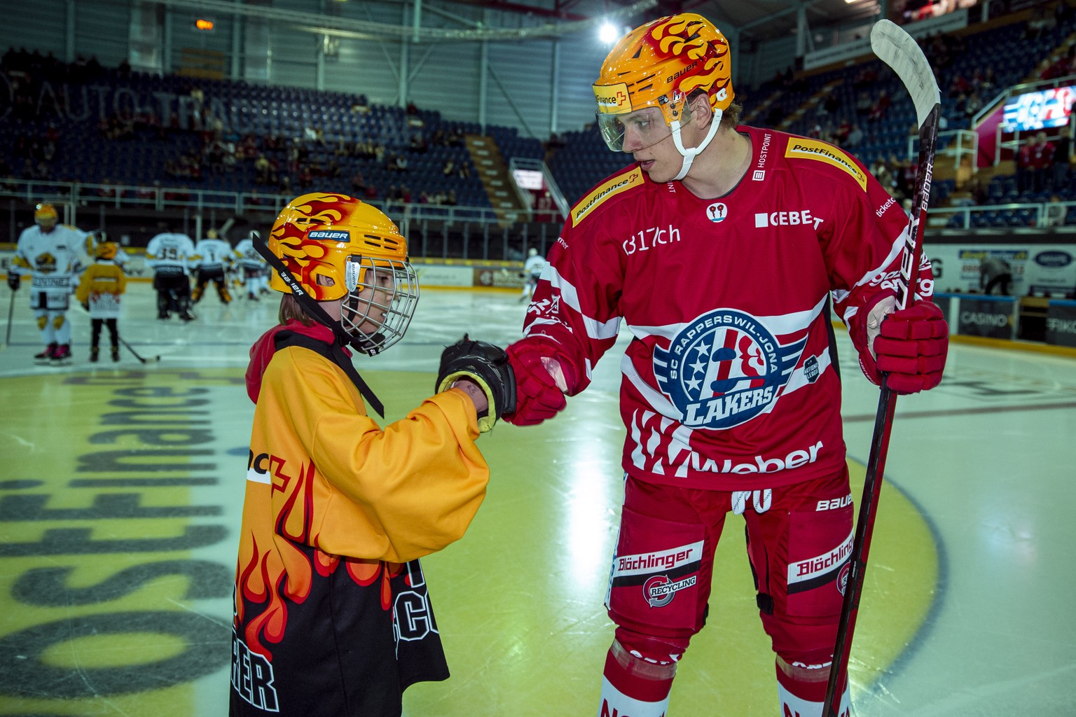 SC Rapperswil-Jona Lakers PostFinance Top Scorer Nando Eggenberger, rechts, beim Abklatschen mit einem PostFinance Einlaufkind waehrend dem Eishockey-Meisterschaftsspiel der National League zwischen d ...