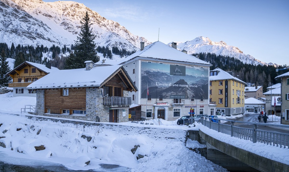 Blick auf das Dorf San Bernardino mit Werbeplakat des Projektes "San Bernardino Swiss Alps", aufgenommen am Donnerstag, 7. Dezember 2023, in San Bernardino. Die Gesellschaft San Bernardino S ...