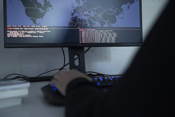 ZUM THEMA CYBERCRIME STELLEN WIR IHNEN HEUTE FOLGENDE SYMBOLBILDER ZUR VERFUEGUNG --- [Symbolic Image / Staged Image] A hacker is using a computer showing a Traceroute world map, photographed on July  ...