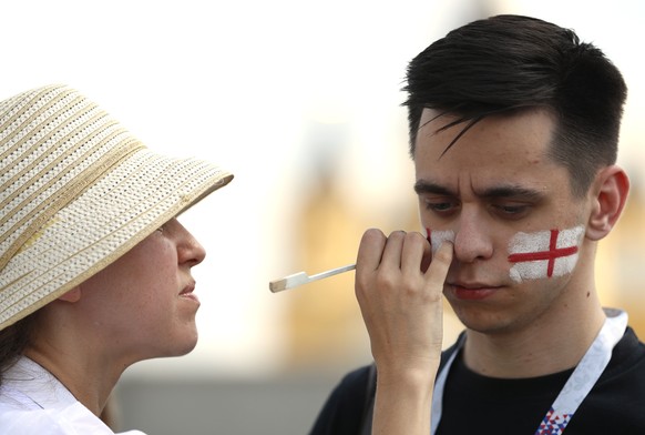 A soccer fan&#039;s face painted by a street artist in the colors of the England national flag outside the venue for the group G match between England and Panama at the 2018 soccer World Cup at the Ni ...