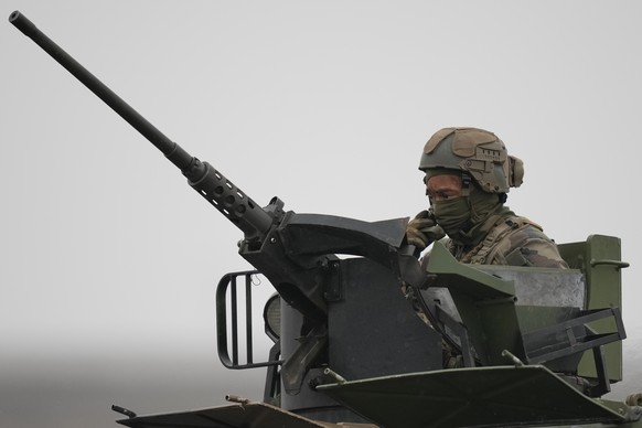 A French serviceman sits behind a machinegun during an exercise at a training range in Smardan, eastern Romania, Wednesday, Jan. 25, 2023. Around 600 French soldiers deployed to Romania as part of a N ...
