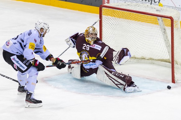 Le joueur fribourgeois, Viktor Stalberg, gauche, a la lutte pour le puck avec le gardien Genevois, Robert Mayer, droite, lors du match du championnat suisse de hockey sur glace de National League LNA, ...