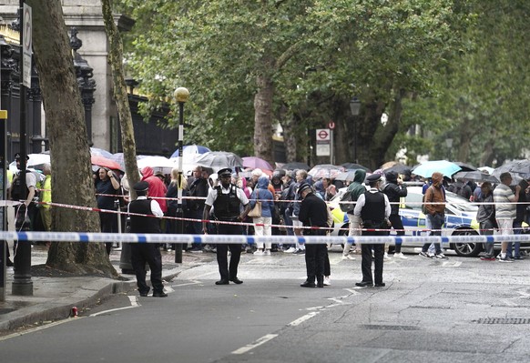 Police and bystanders stand outside the British Museum after an incident close to the museum, in London, Tuesday, Aug. 8, 2023. Police in London say they have arrested a man suspected of stabbing anot ...