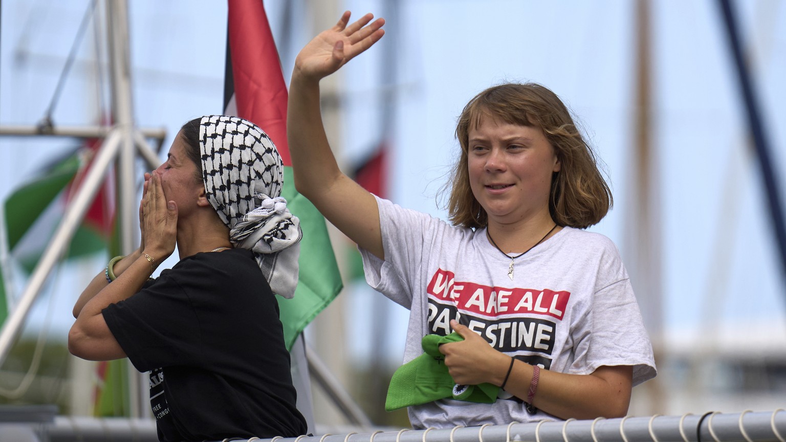 Swedish climate activist Greta Thunberg waves from a boat taking part in a civilian flotilla bound for Gaza, aiming to break the Israeli blockade and deliver humanitarian aid, in Barcelona, Spain, Sun ...
