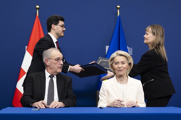 Swiss Federal President Guy Parmelin, left, and European Commission President Ursula von der Leyen sign a package of bilateral agreements between the European Union and Switzerland, in Brussels, Belgi ...