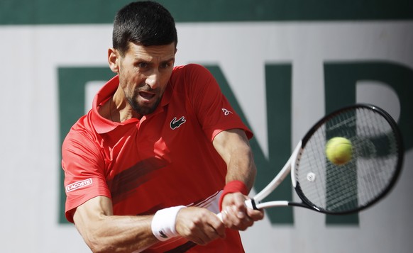 epa09974826 Novak Djokovic of Serbia hits a backhand in the men's second round match against Alex Molcan of Slovakia during the French Open tennis tournament at Roland Garros in Paris, France, 25 May 2022.  EPA/CHRISTOPHE PETIT TESSON