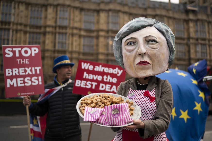 epa07221280 Anti-Brexit campaigner dressed as British Prime Minister Theresa May holding a plate of fudge poses for photographers outside Houses of Parliament in Central London, Britain, 10 December 2 ...