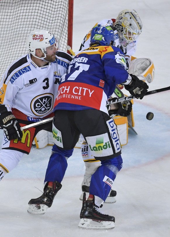 Die Tessiner Julien Vauclair und Torhueter Elvis Merzlikins, von links, und der Bieler Marco Maurer, Mitte, kaempfen um den Puck beim Eishockeyspiel der National League A zwischen dem EHC Biel und dem ...