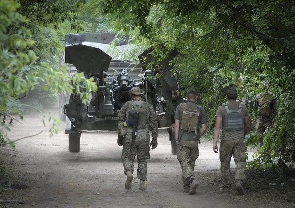 Ukrainian soldiers move a U.S.-supplied M777 howitzer into position to fire at Russian positions in Ukraine&#039;s eastern Donbas region Saturday, June 18, 2022. (AP Photo/Efrem Lukatsky)