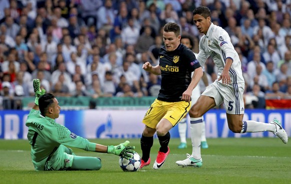 epa05941076 Real Madrid&#039;s goalkeeper Keylor Navas (L) saves a ball before Atletico Madrid&#039;s Kevin Gameiro (C) next to Real Madrid&#039;s Raphael Varane (R) the UEFA Champions League semifina ...