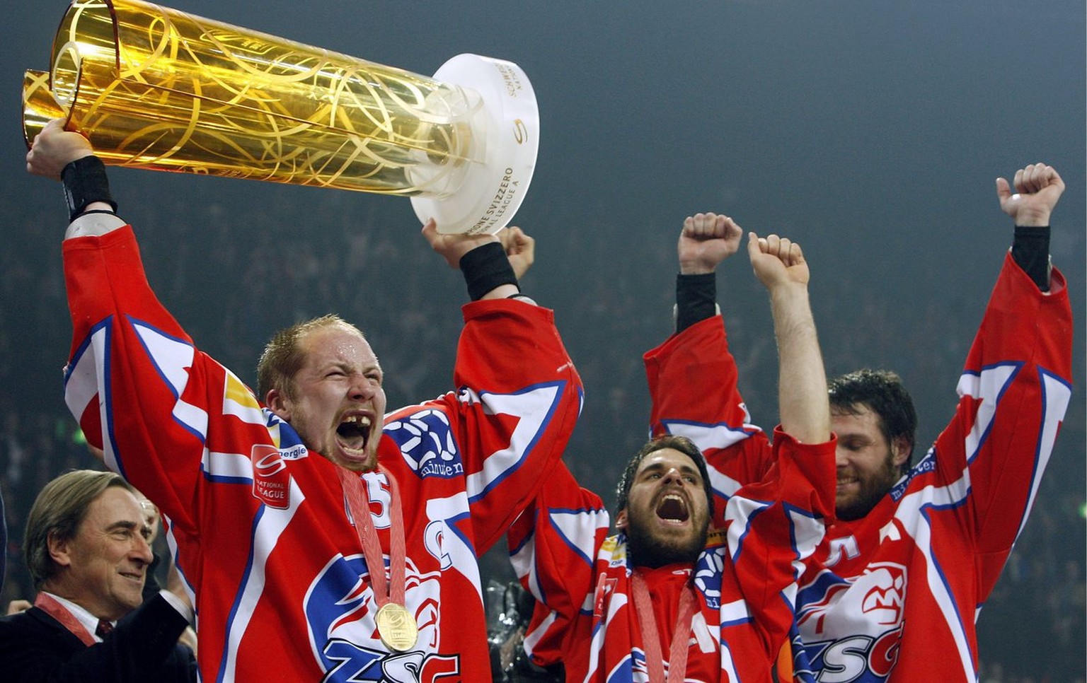 ZSC Lions Spieler Mathias Seger, Adrian Wichser und Ryan Gardner, von links, jubeln mit dem Pokal nach dem 6. Eishockey Play Off Finalspiel zwischen den ZSC Lions und dem HC Genf-Servette im Hallensta ...