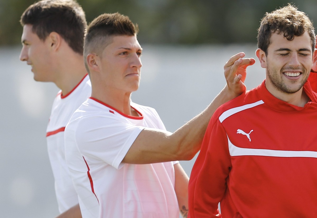 Switzerland's Steven Zuber, 2nd from left, and Josip Drmic, 2nd from right, flick the ears of teammate Admir Mehmedi, center, during a training session of the Swiss Olympic national soccer team a ...