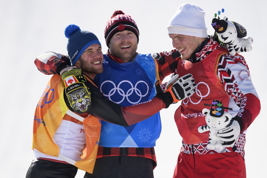 Silver medalist Marc Bischofberger of Switzerland, gold medalist Brady Leman of Canada, and bronze medalist Sergej Ridzik (OAR), from left, pose on the podium after the Men Freestyle Skiing Ski Cross  ...