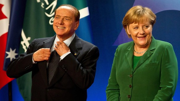 epa02991028 German Chancellor Angela Merkel (R) and Italian President Silvio Berlusconi wait for the group picture at the G20 summit in Cannes, France, 03 November 2011. The G20 leaders are in Cannes  ...