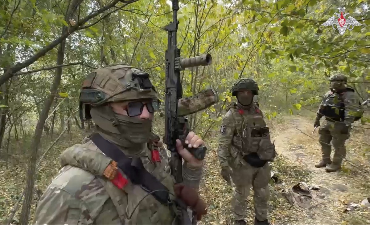 In this photo taken from a video released by the Russian Defense Ministry on Monday, Sept. 23, 2024, Russian soldiers patrol a trail in the Russian - Ukrainian border area in ??the Kursk region, Russi ...