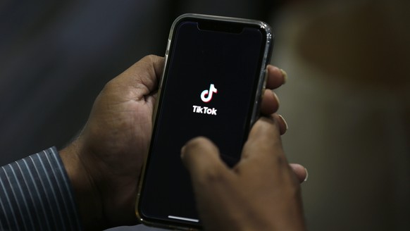 FILE - In this July 21, 2020 file photo, a man opens social media app &#039;TikTok&#039; on his cell phone, in Islamabad, Pakistan. The owner of TikTok has chosen Oracle over Microsoft as the American ...
