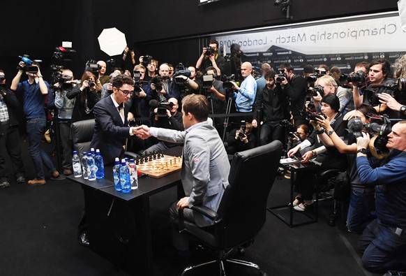 epa07195072 Norway&#039;s World Chess Champion Magnus Carlsen (C) plays against US challenger Fabiano Caruana (L) at the tie-break game during the World Chess Championship 2018 in London, Britain, 28  ...