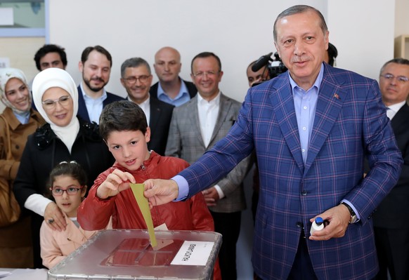 epa05910546 Turkish President Recep Tayyip Erdogan (R) cast his vote with his grandson Mehmet Akif (L) as his wife Emine (L-back) and granddaughter Mahinur acompany him at a polling station for a refe ...