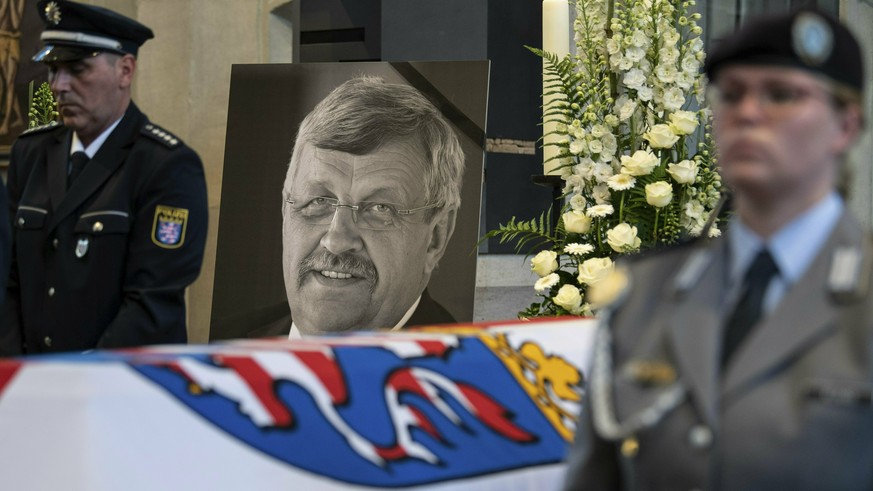 FILE-In this June 13, 2019 file photo a picture of Walter Luebcke stands behind his coffin during the funeral service in Kassel, Germany. Germany&#039;s top security official says the far-right extrem ...