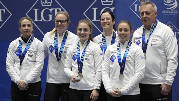 Switzerland's skip Silvana Tirinzoni, Alina Paetz, Selina Witschonke, Carole Howald, Stefanie Berset and coach Pierre Charette, from left to right, celebrate during the medal ceremony at the Worl ...