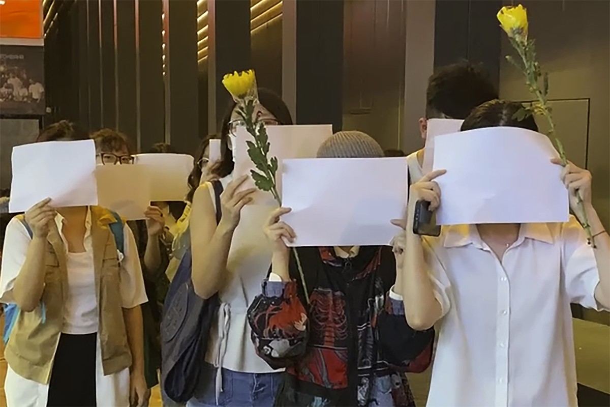 Protesters hold up blank white papers during a commemoration for victims of a recent Urumqi deadly fire in Central in Hong Kong, Monday, Nov. 28, 2022. Students in Hong Kong chanted