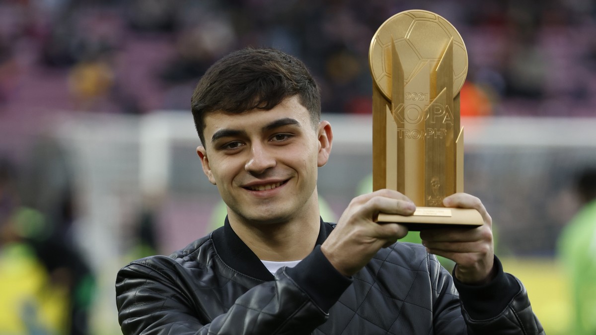 Barcelona's Pedri holds up his trophy of the 2021 Kopa Ballon d'Or for best young player prior the Spanish La Liga soccer match between Barcelona and Real Betis at the Camp Nou stadium, in B ...