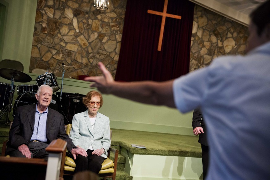 Former President Jimmy Carter, left, sits with his wife, Rosalynn, as they wait to pose for photos after Carter taught Sunday School class at Maranatha Baptist Church in his hometown of Plains, Ga., S ...