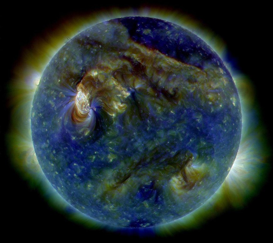 In this false-color ultraviolet image, the Sun shows a C3-class solar flare (white area on upper left), a solar tsunami (wave-like structure, upper right) and multiple filaments of plasma following a  ...